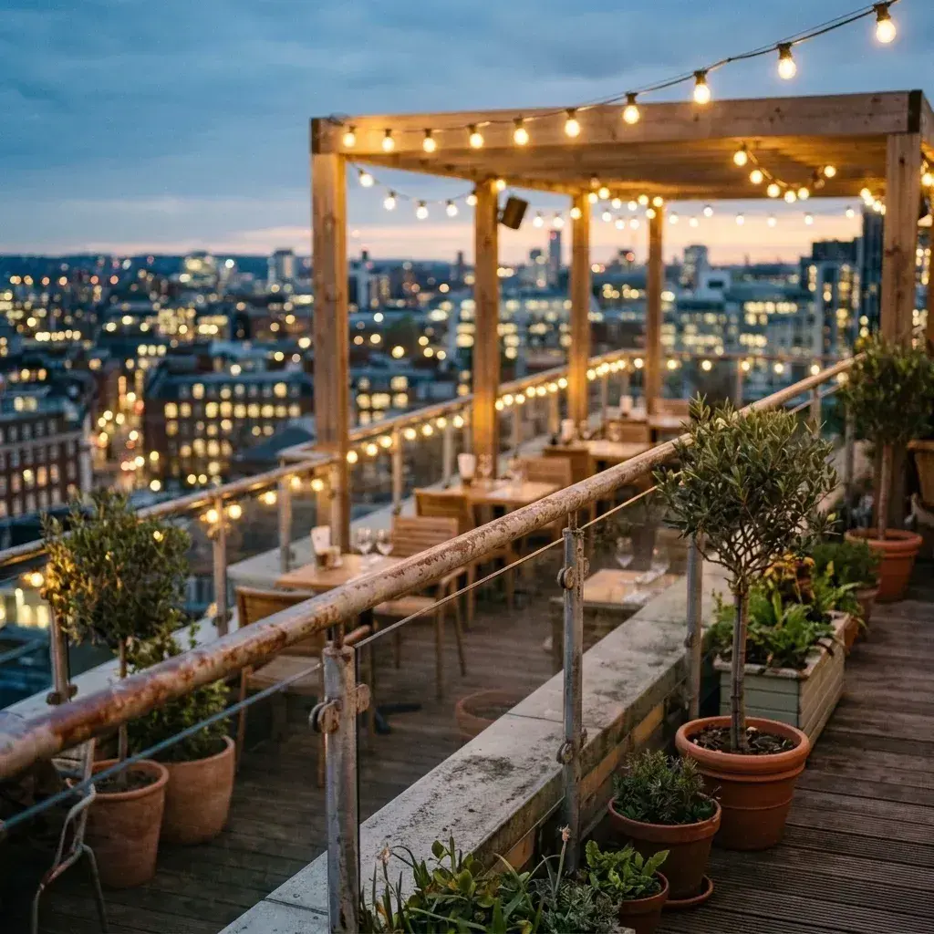 An empty rooftop terrace with wooden furniture and potted plants overlooking a city skyline at dusk.