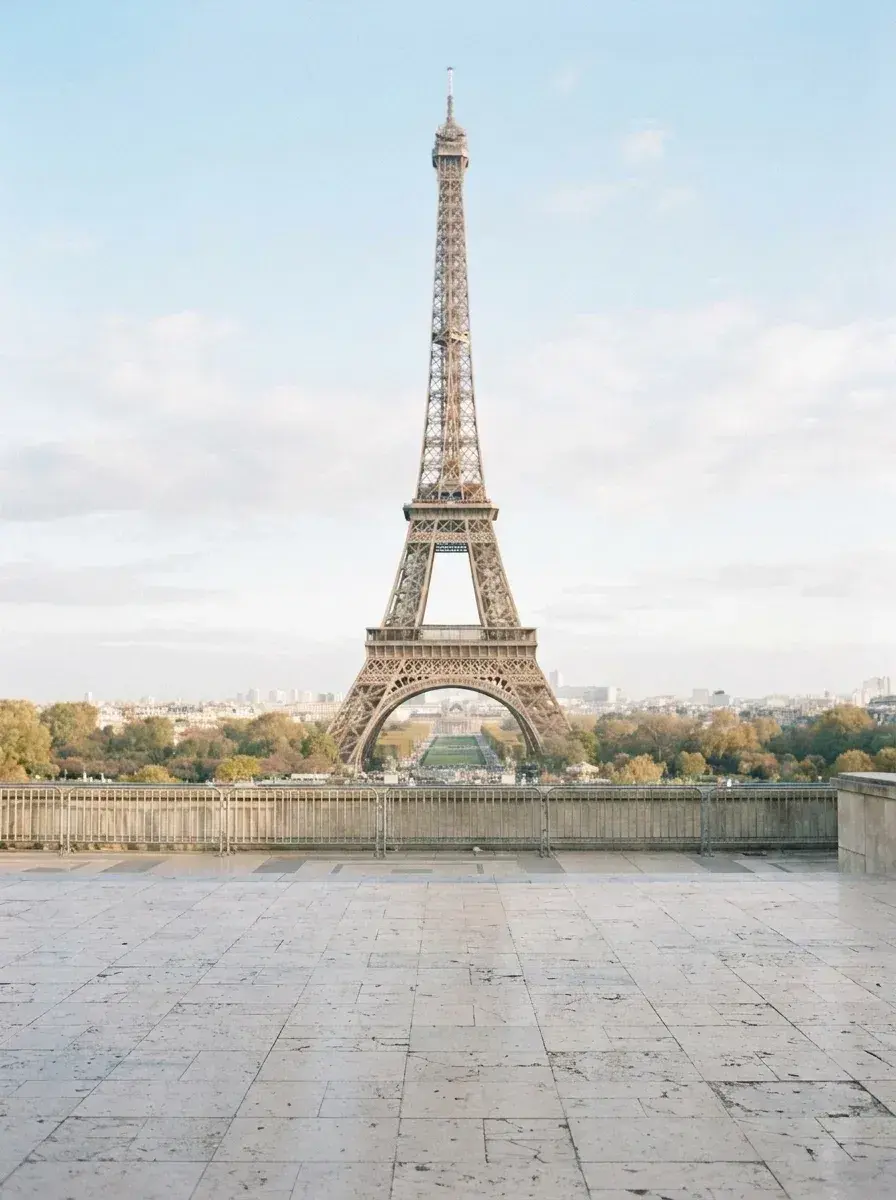 The same stone terrace in Paris is empty, showing an unobstructed view of the Eiffel Tower.