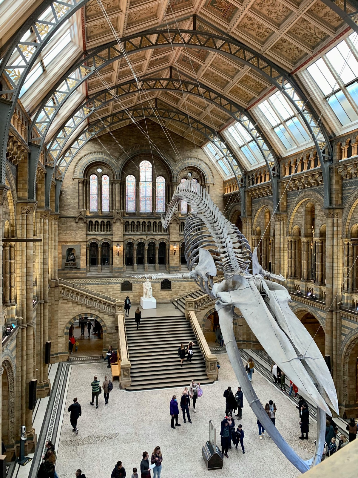 Natural History Museum Hintze Hall with blue whale skeleton and crowds of visitors - before AI removal